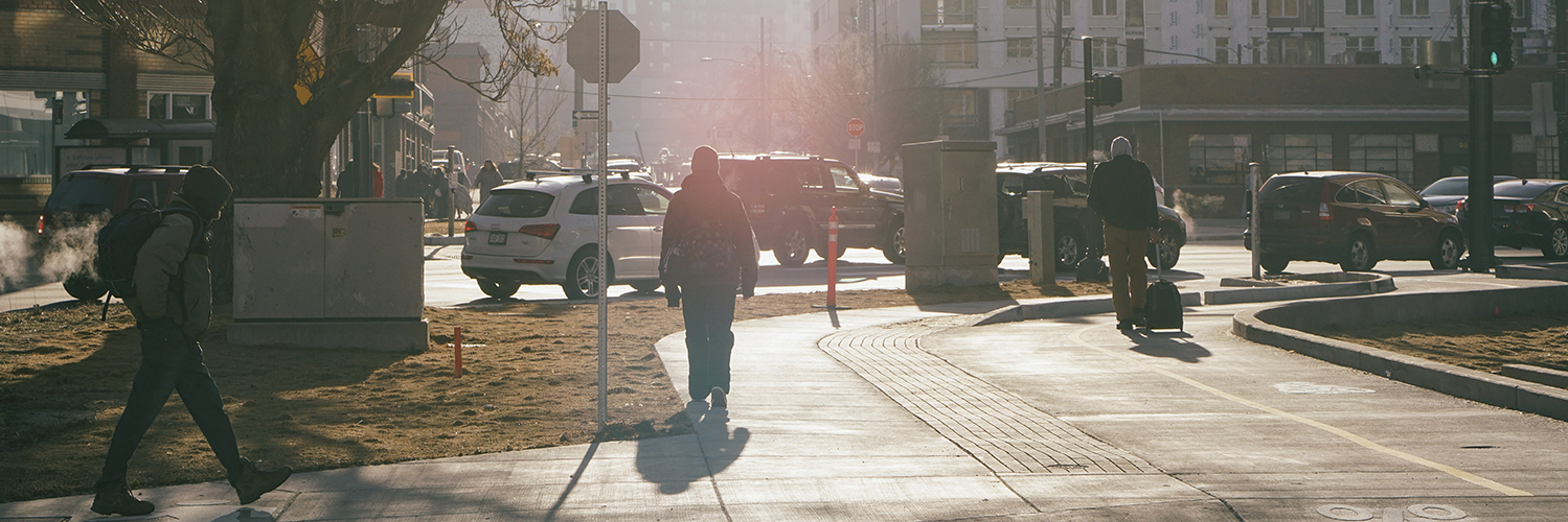people walking in a urban neighborhood as the sun comes up