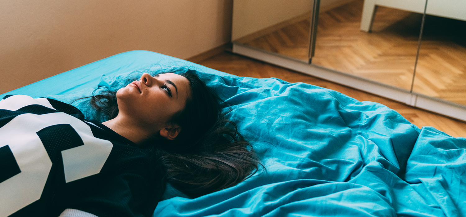 Young woman reclines on bed