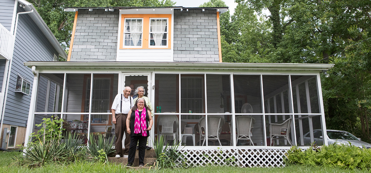 Family stands in front of their home