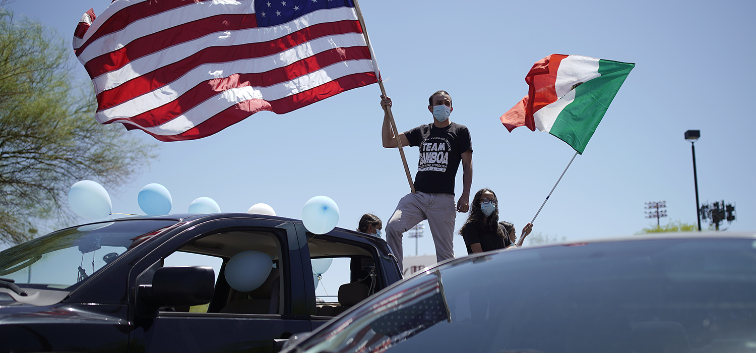 Man waves flag during rally for immigrant workers and families