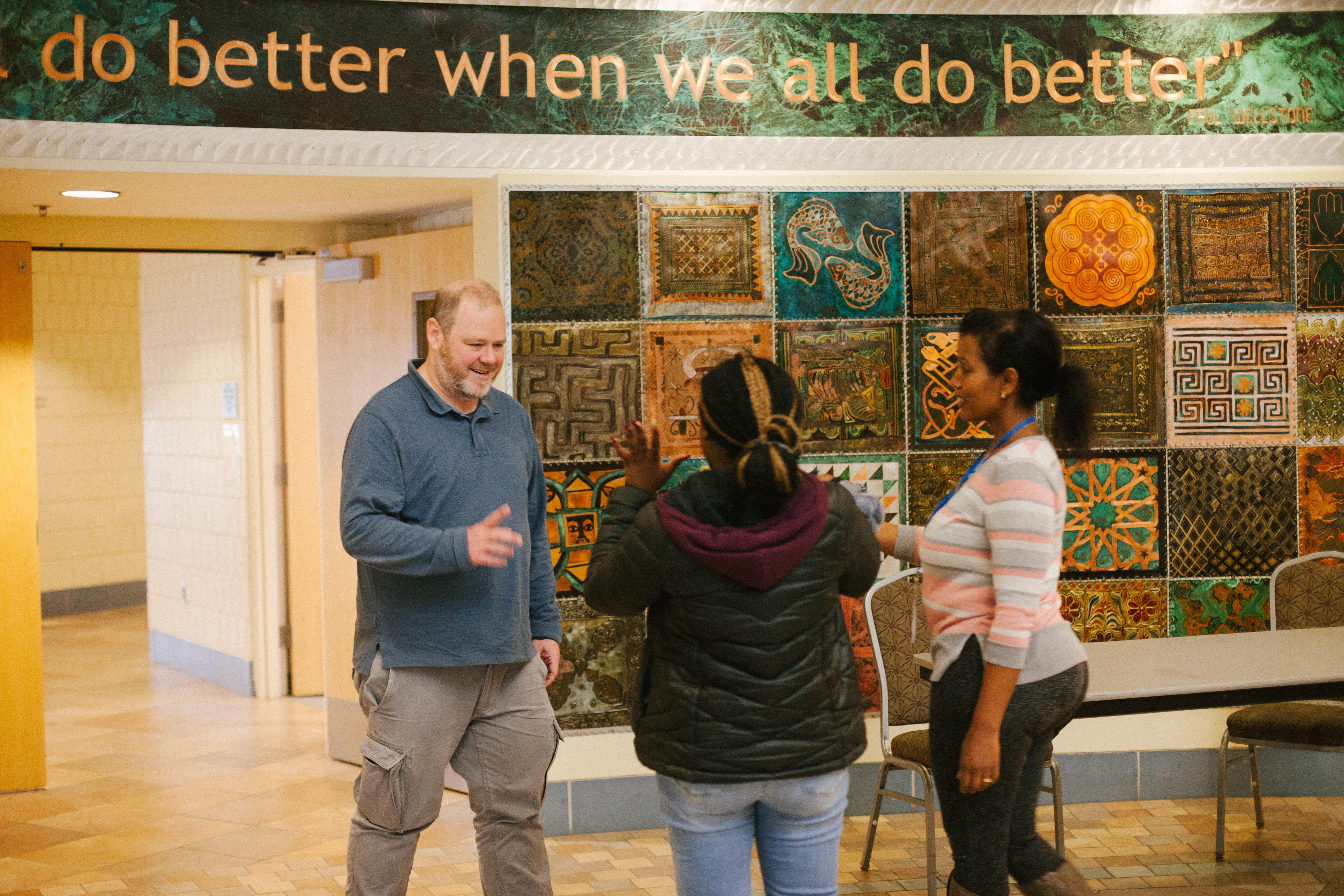 Frewoine Gebrehiwot, family coach and site coordinator at Neighborhood House, walks a client to meet Ben Weiss, an attorney with Southern Minnesota Regional Legal Services. 