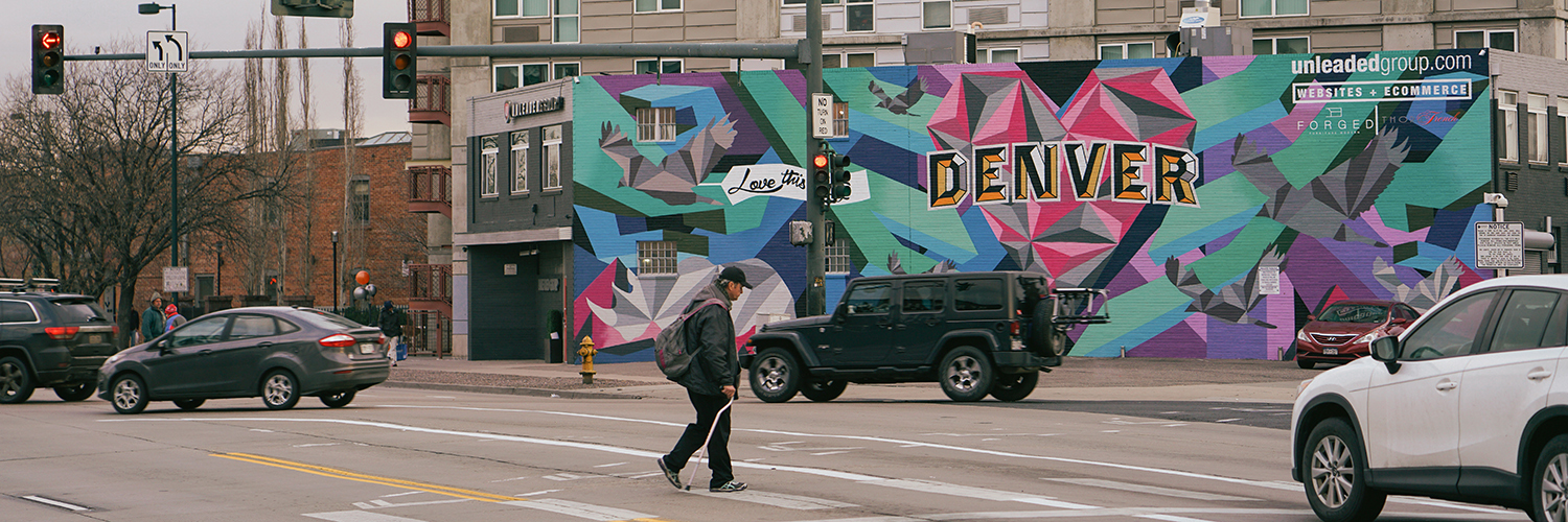 a man walking across a street in Denver