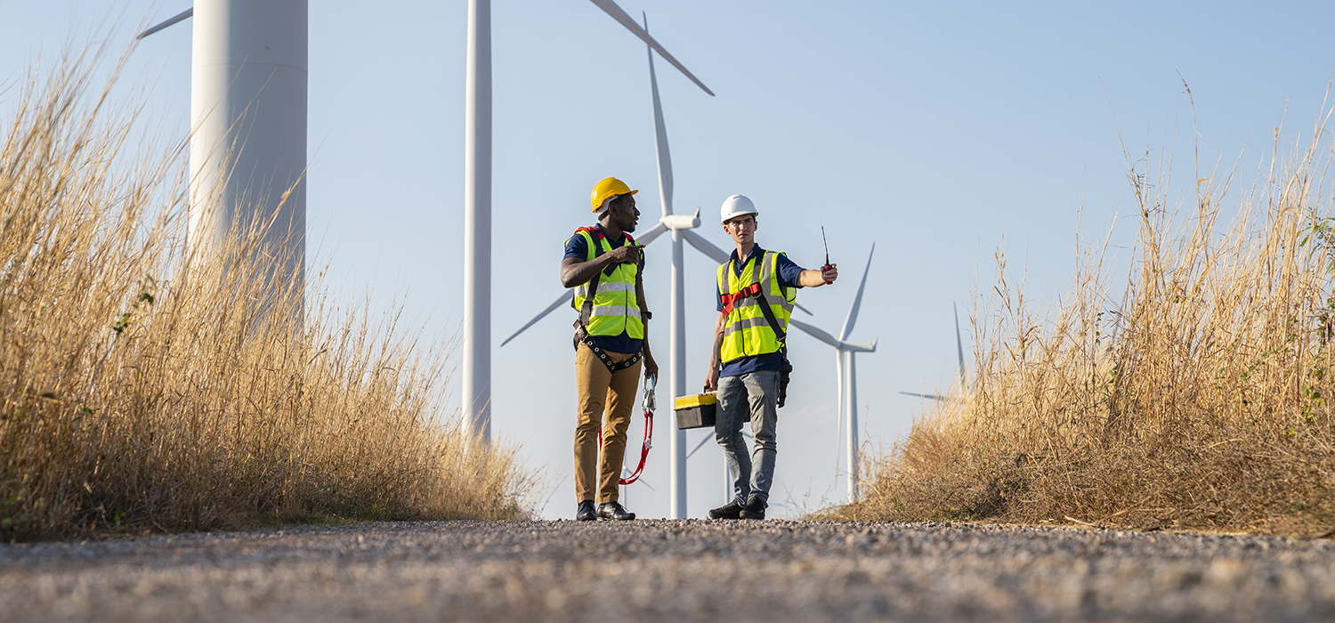 Two workers outside a windmill plant.