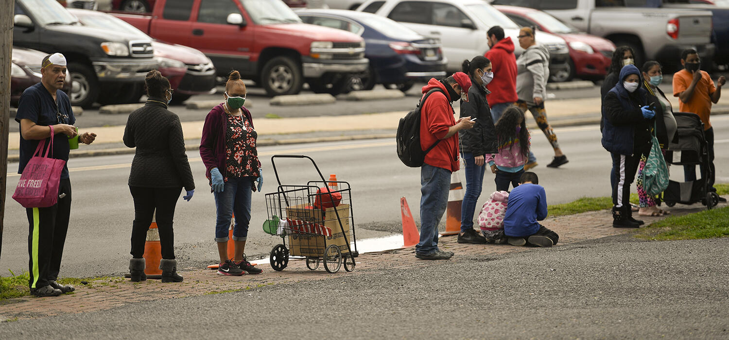  People stand in line along Greenwich Street next to Hope Rescue mission.