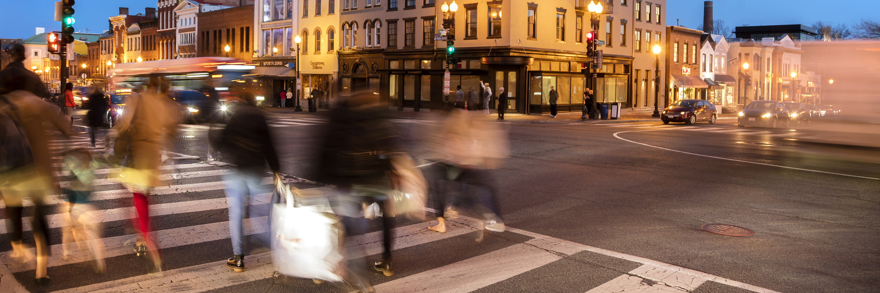 Pedestrians crossing street at dusk in Georgetown, Washington, DC
