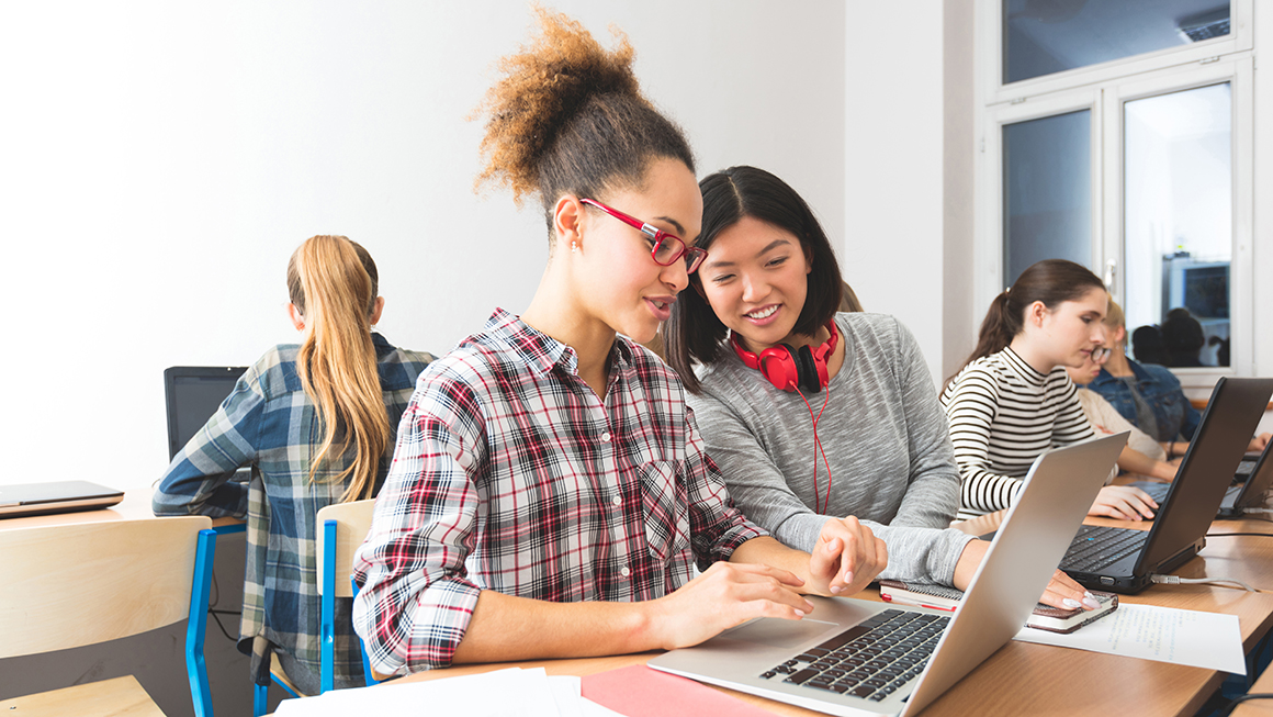 Two students working on a laptop.