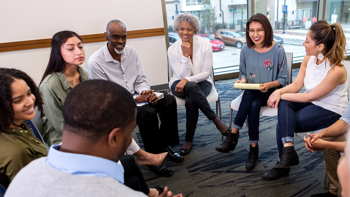 A group of people sitting around a circle.