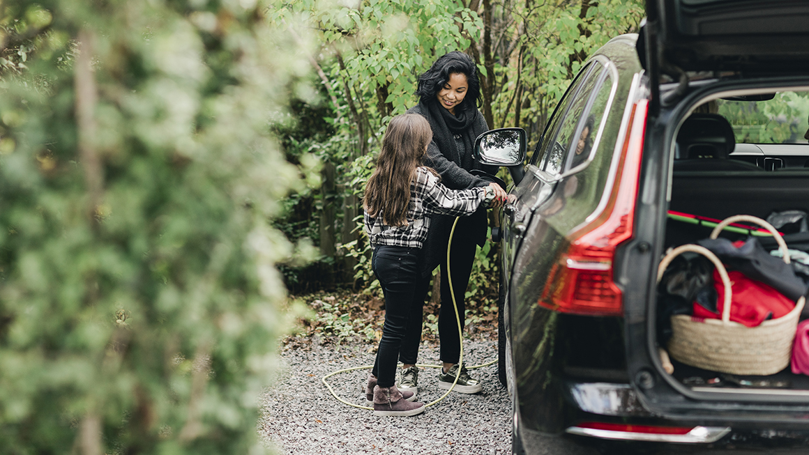 Woman charging an electric car. 