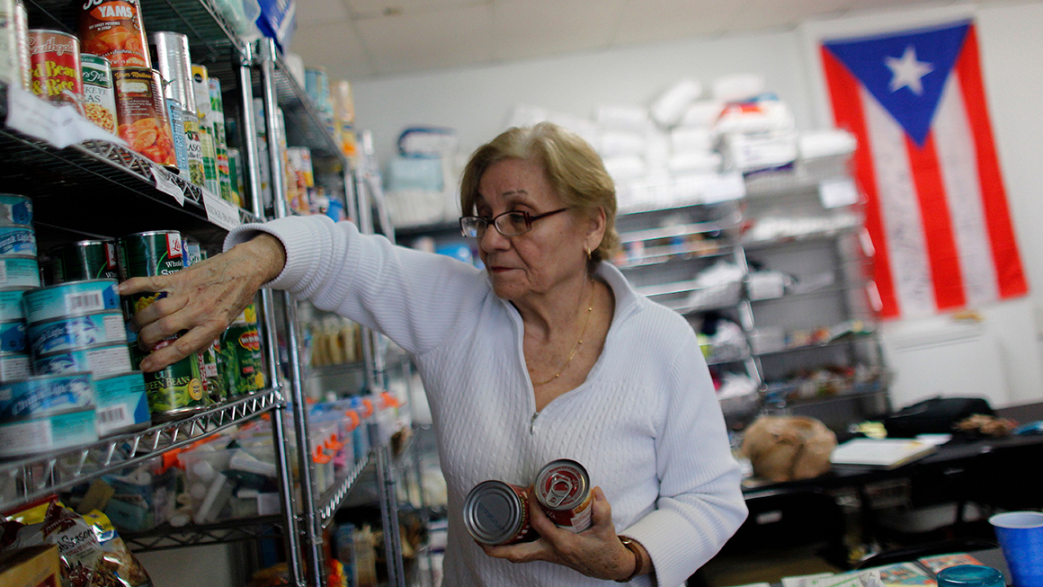 rma Ramos, 71, organises donated canned food into shelves at the Latino Leadership headquarters in Orlando, Florida on December 1, 2017. 
