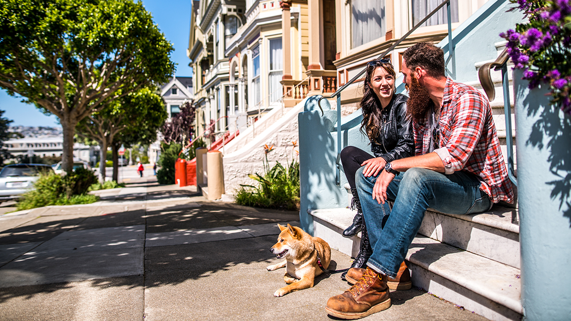 Couple with their dog on their front steps. 