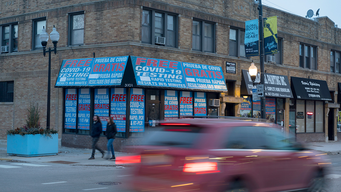 A street corner with a building offering free covid testing. 
