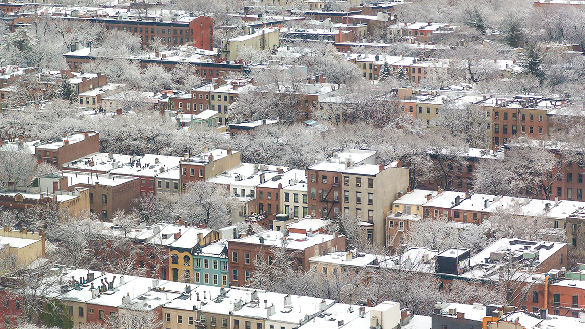 An aerial image of housing with snow on the ground.