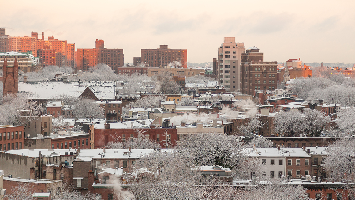 A wide shot of a city with snow on the ground.