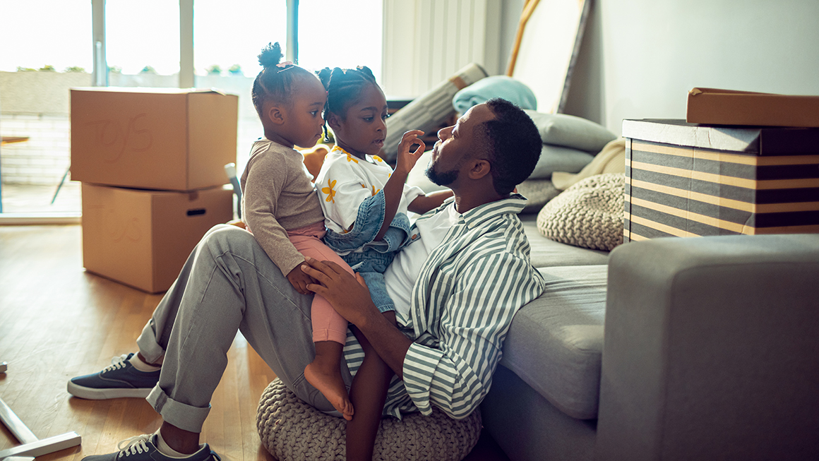 A father and his daughters in their new home.