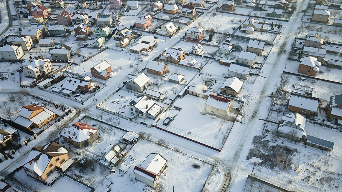 Aerial image of housing with snow on the ground.