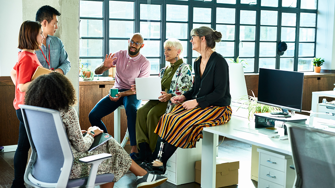 A group of co-workers talking in an office. 