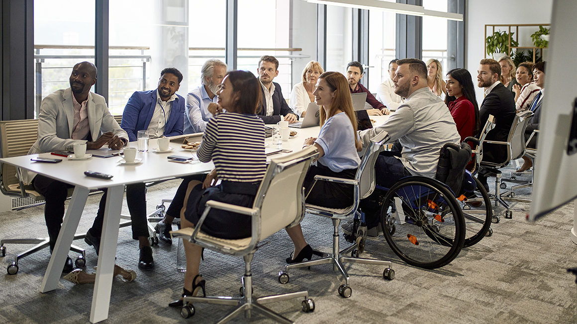 A group of people at a large meeting desk.