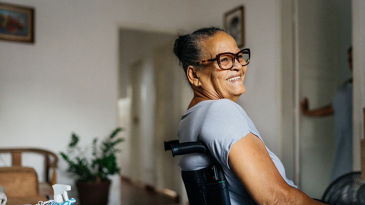 A woman of color in a wheelchair smiling