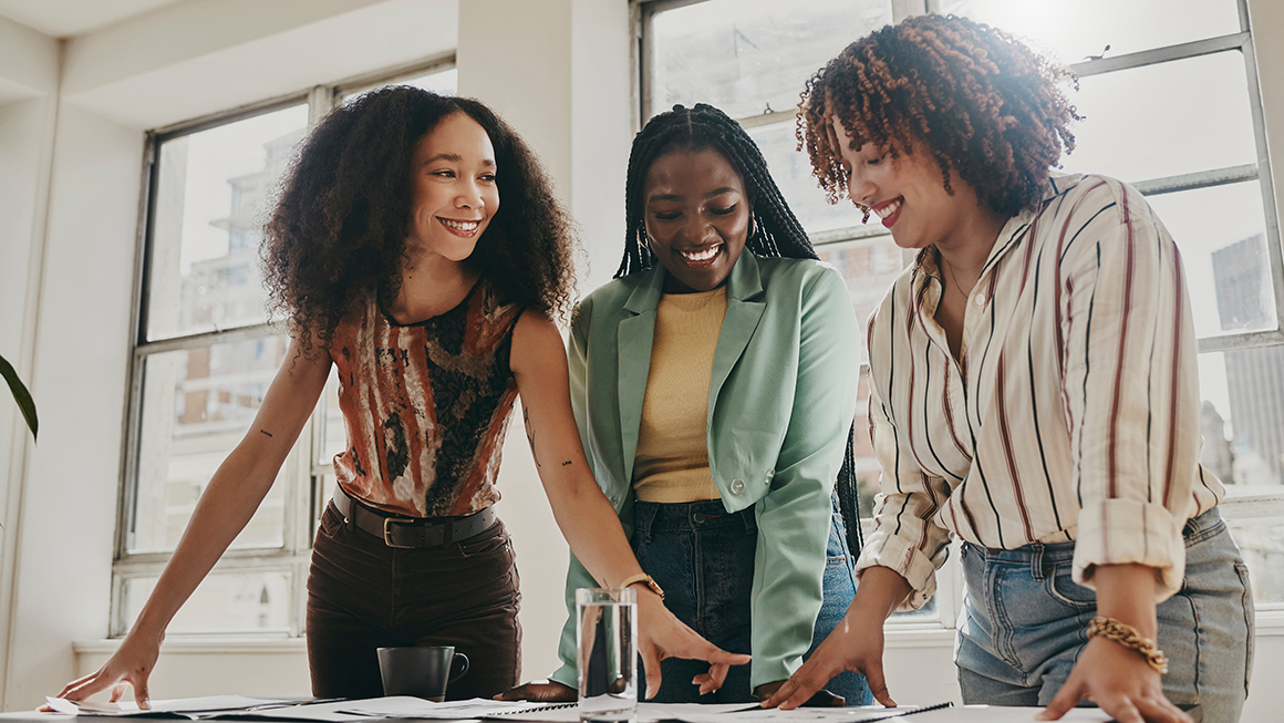 A group of women looking over documents