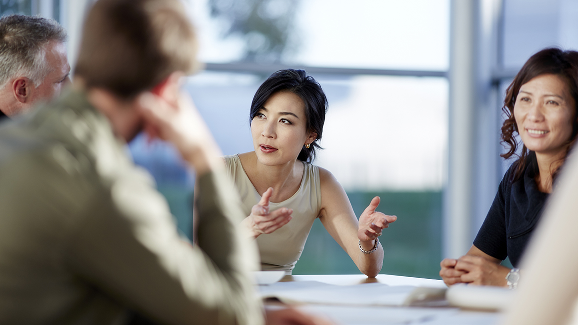 Co-workers talking around a table.