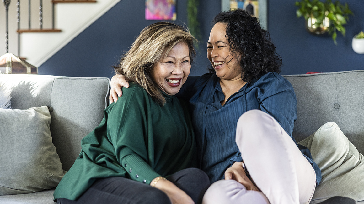 Two women talking on a couch.