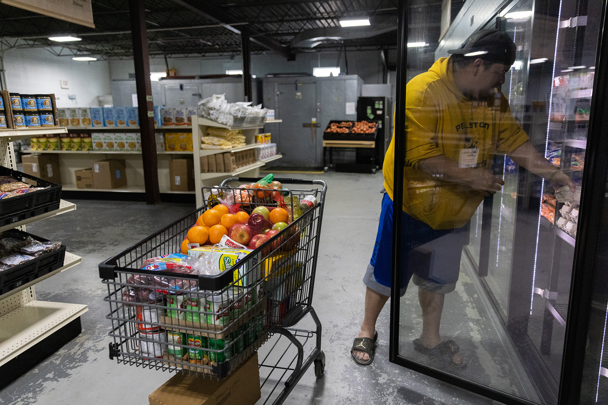 A man selecting food for their monthly food package.
