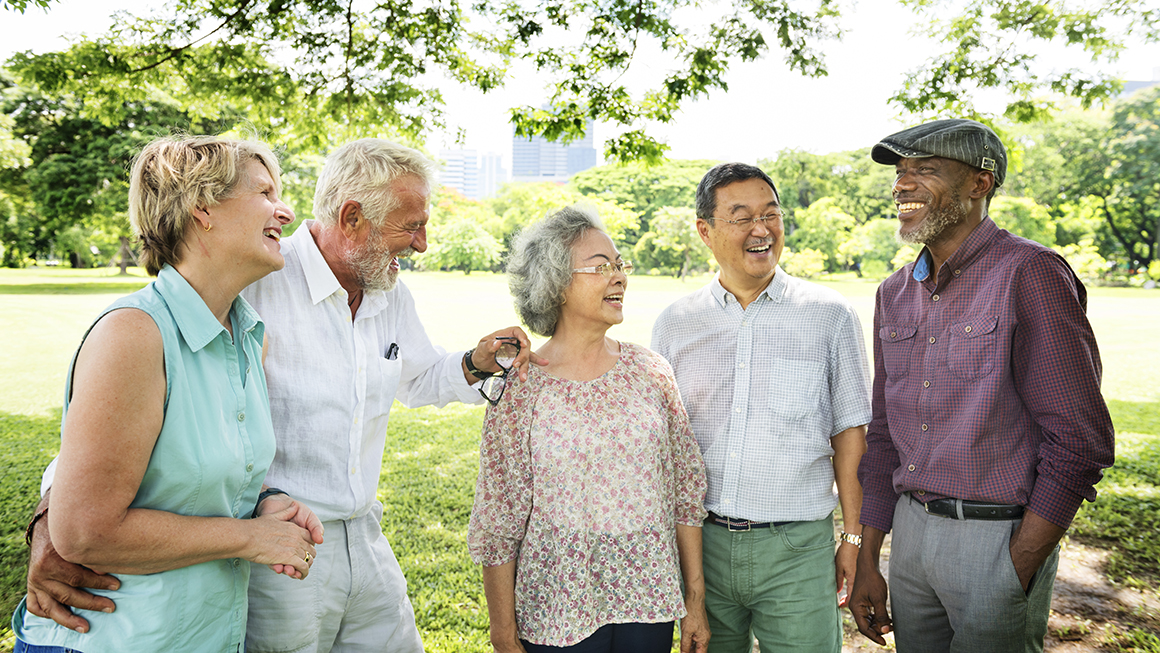 A group of older adults talking to each other outside.