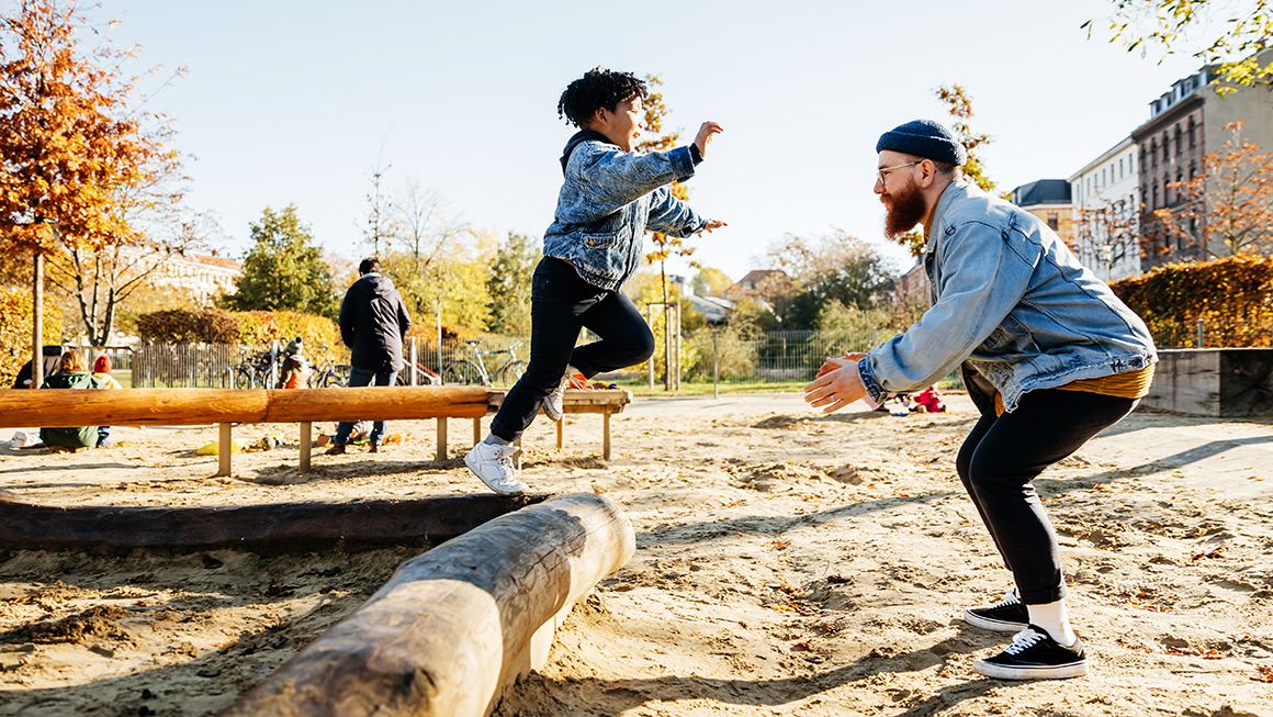 A father playing with his child outside.
