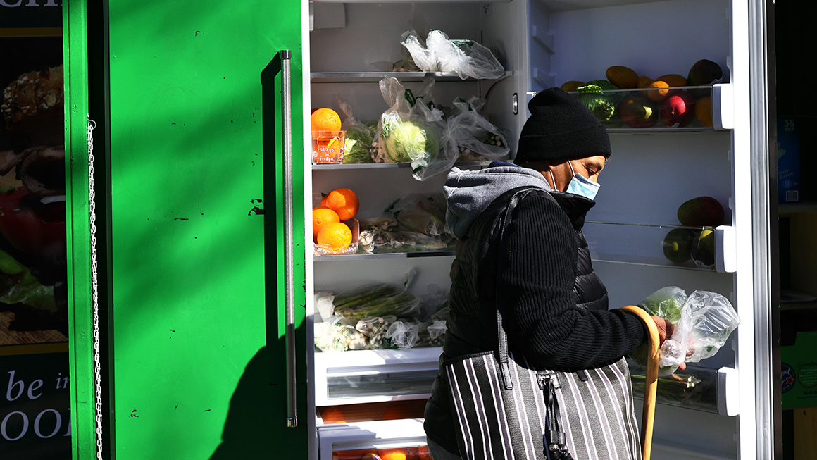 A person picks up food from the Clinton Hill-Fort Greene Mutual Aid group's refrigerator.