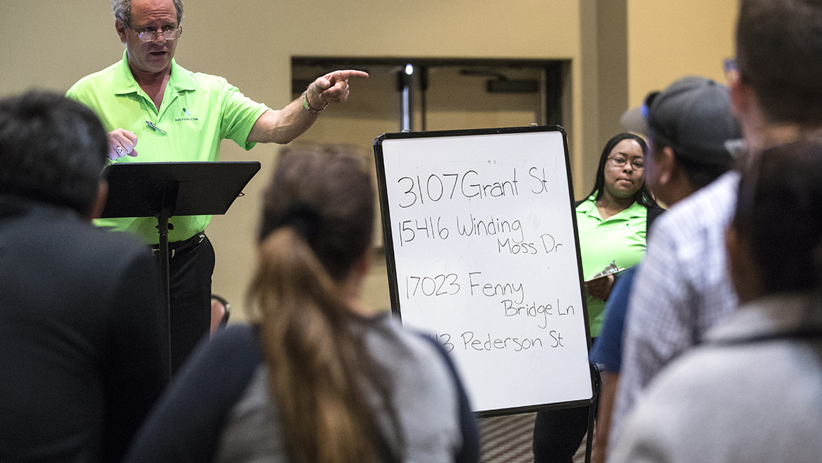 Properties are auctioned off during a foreclosed property sale at the Bayou City Event Center.
