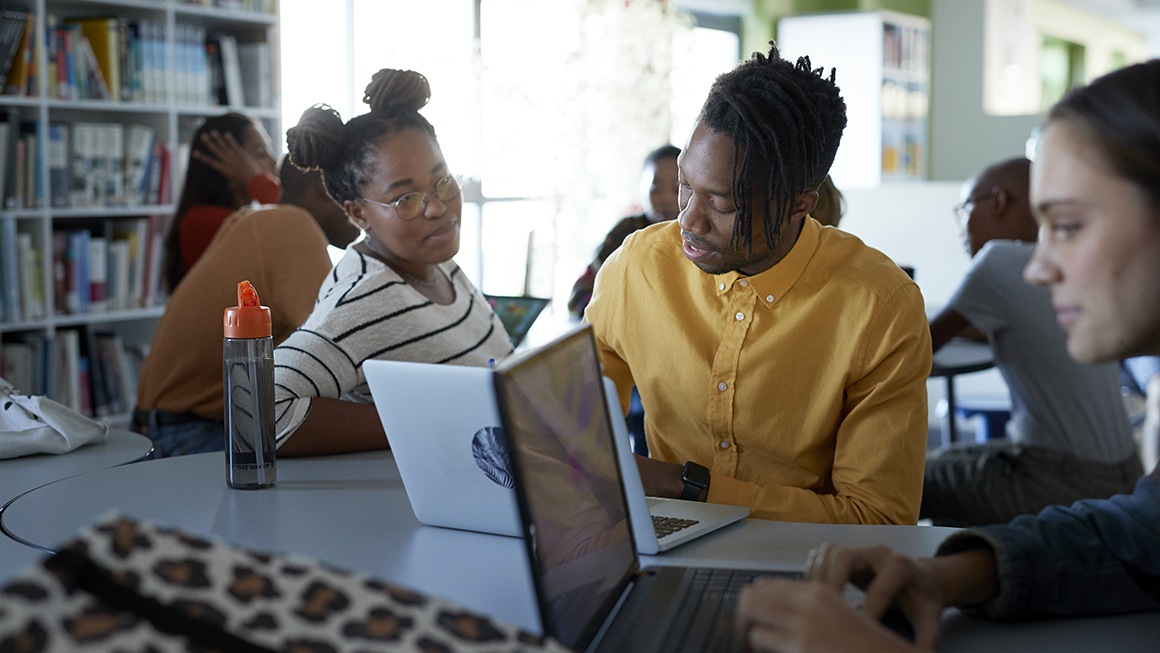Students working together while on their laptops.