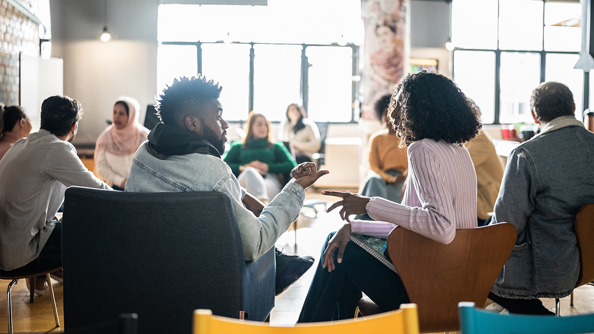 People sitting in chairs in a circle formation.