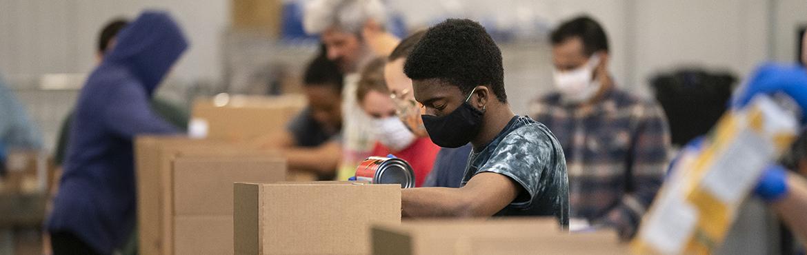 Volunteers pack up boxes of food to be distributed to those in need at the distribution center of the Capital Area Food Bank on April 9, 2020 in Washington, DC.