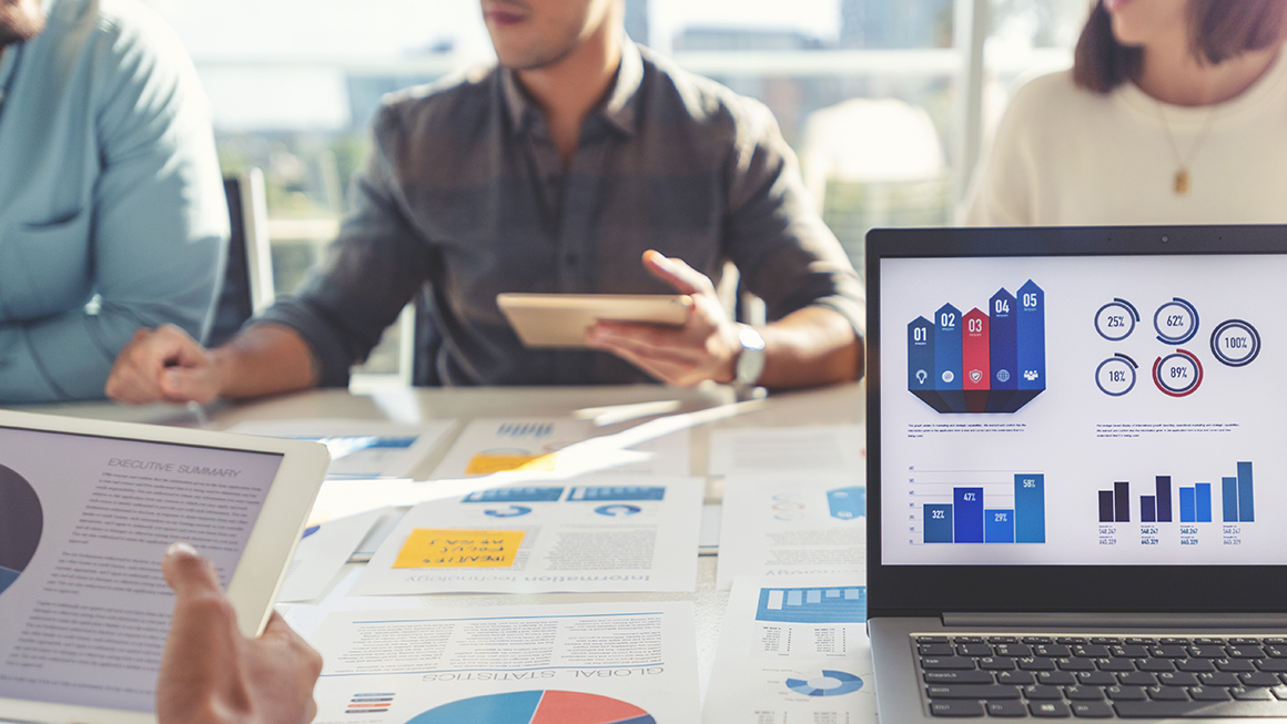 People at work looking at graphs and other documents.