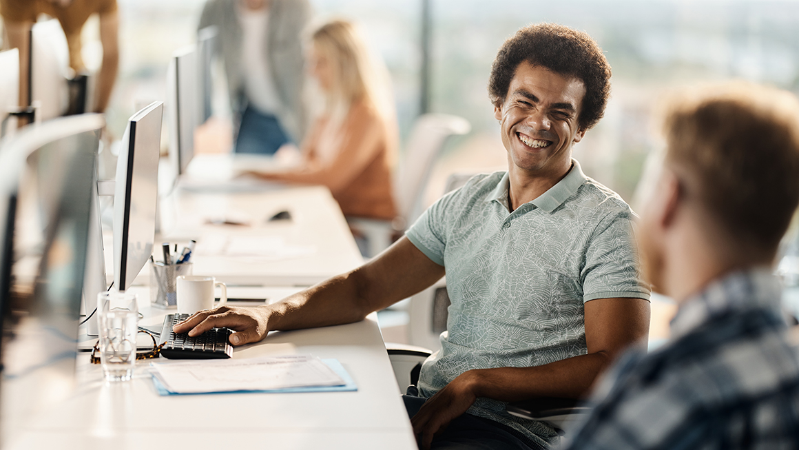 Two people sitting at desks. 