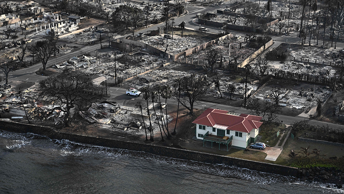 An aerial image shows a red roofed house that survived the fires surrounded by destroyed homes and buildings burned to the ground in the historic Lahaina in the aftermath of wildfires in western Maui in Lahaina, Hawaii.