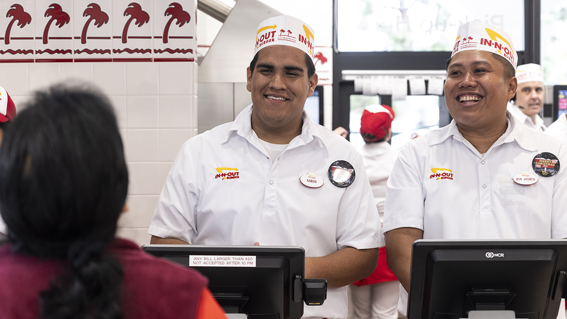 Two in-and-out workers greeting a customer.