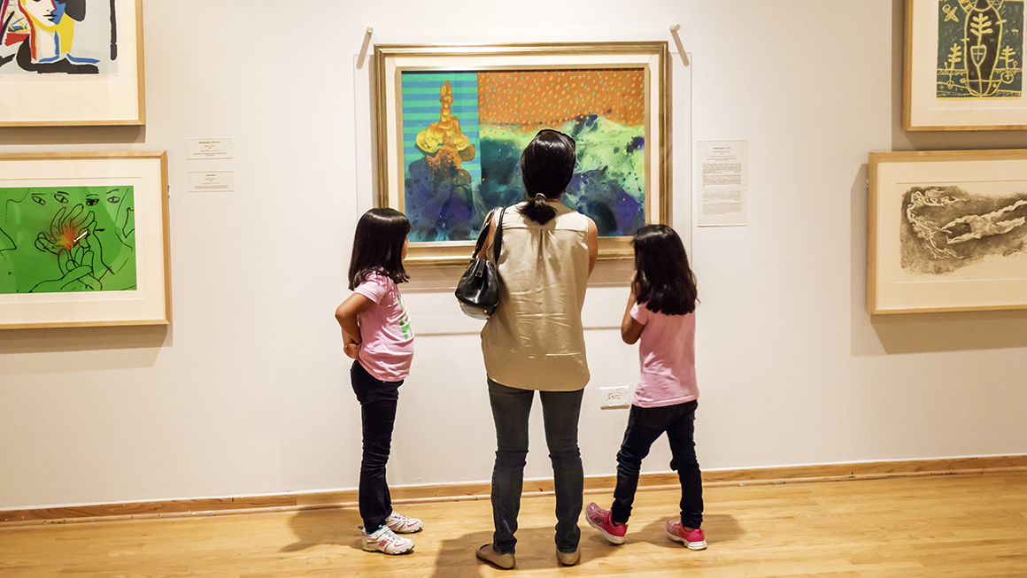 A family looking at a painting inside the National Museum of Mexican Art in Pilsen.