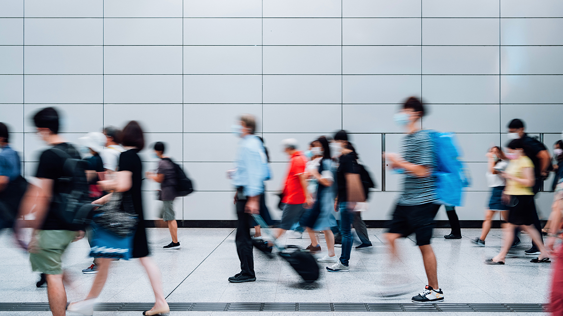 A blury image of people walking down a busy street.
