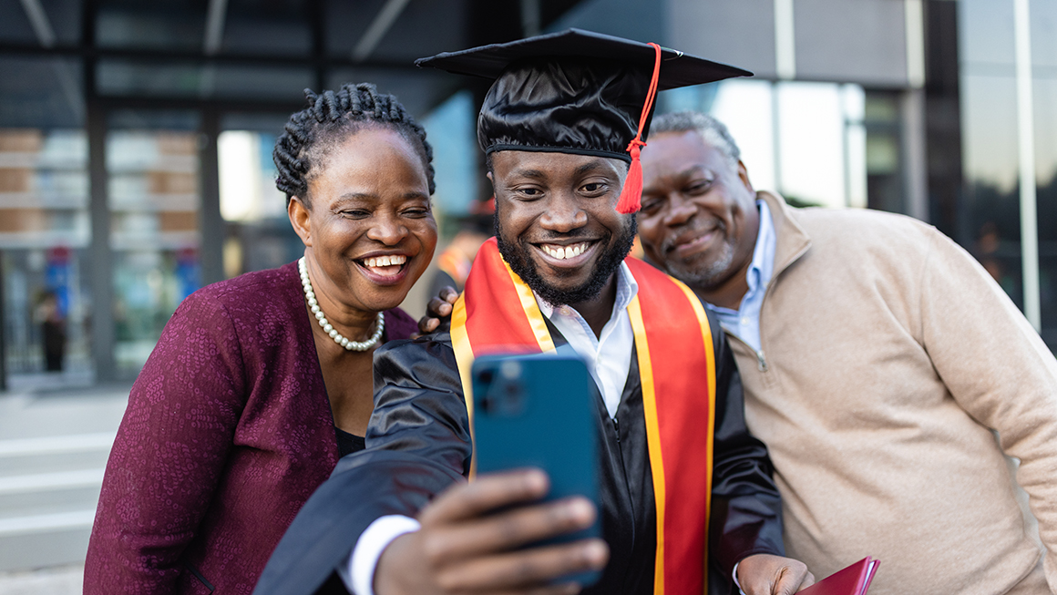A college graduate taking a photo with his parents.