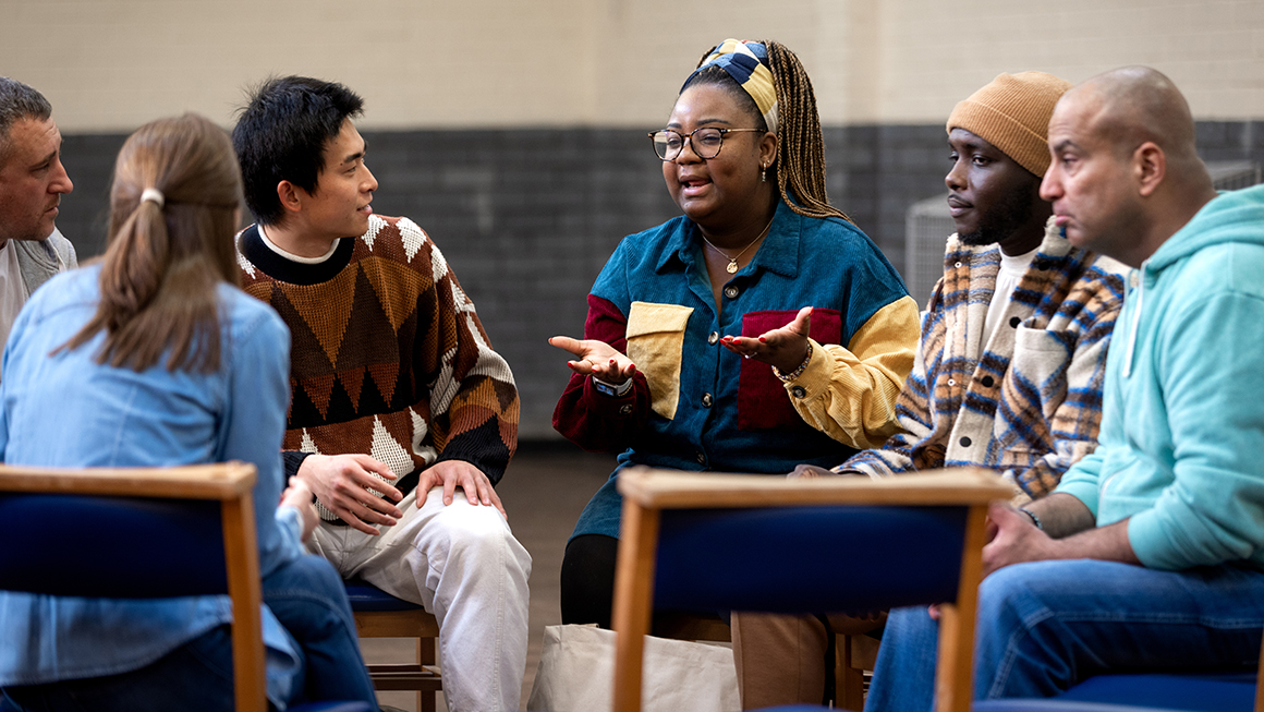 A group of people talking to eachother inside. 