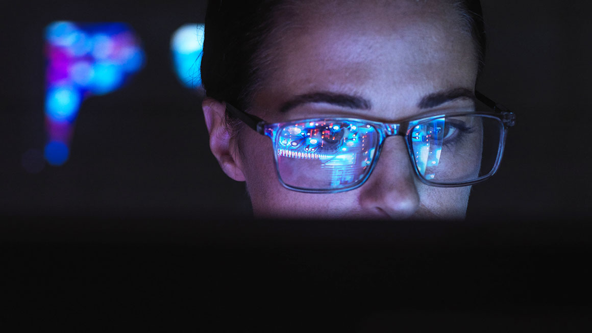 A person's face illuminated by a computer screen.