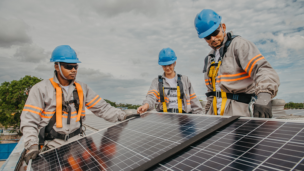 photo of workers working on solar panels