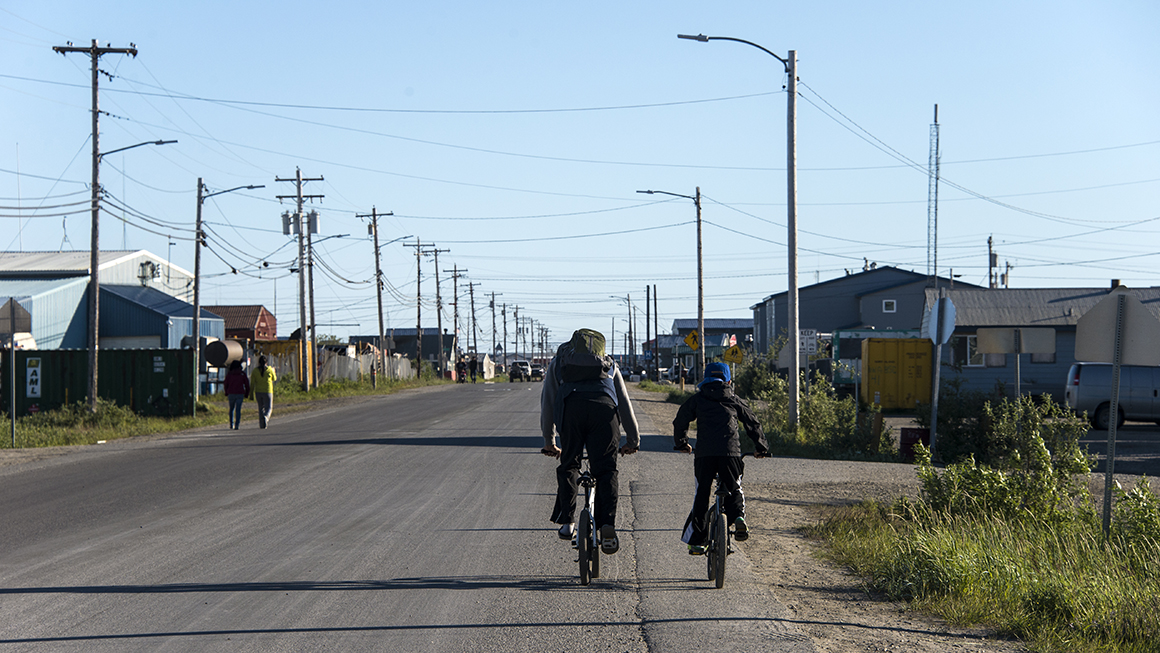 photo of two cyclists riding together on a big road