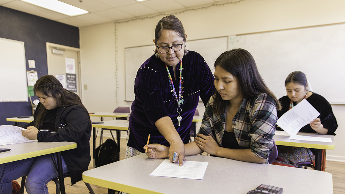 photo of teacher working with student in classroom