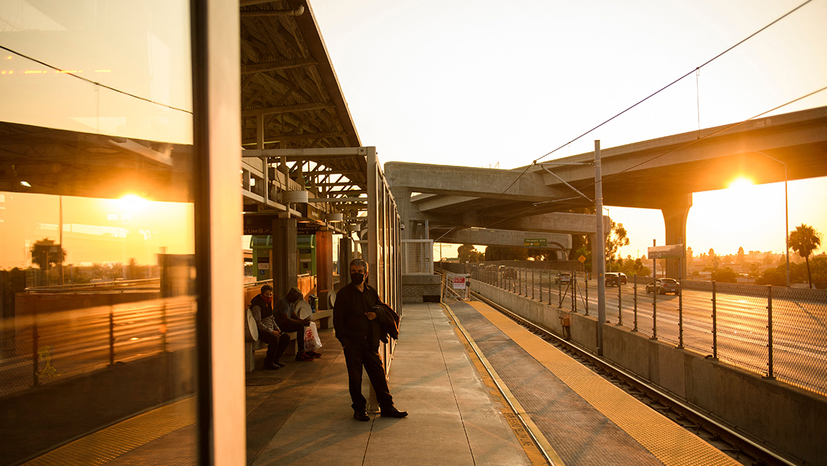 Transit passengers wear face masks as they wait to board the Metro