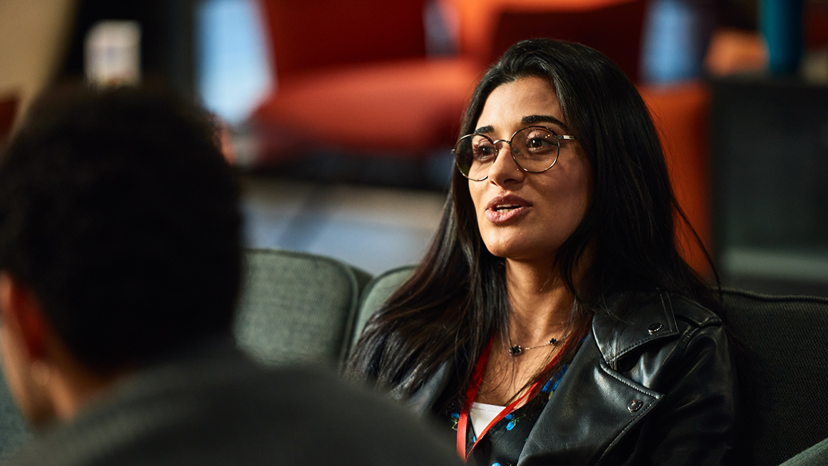 photo of Middle Eastern businesswoman talking to co-workers during break at seminar