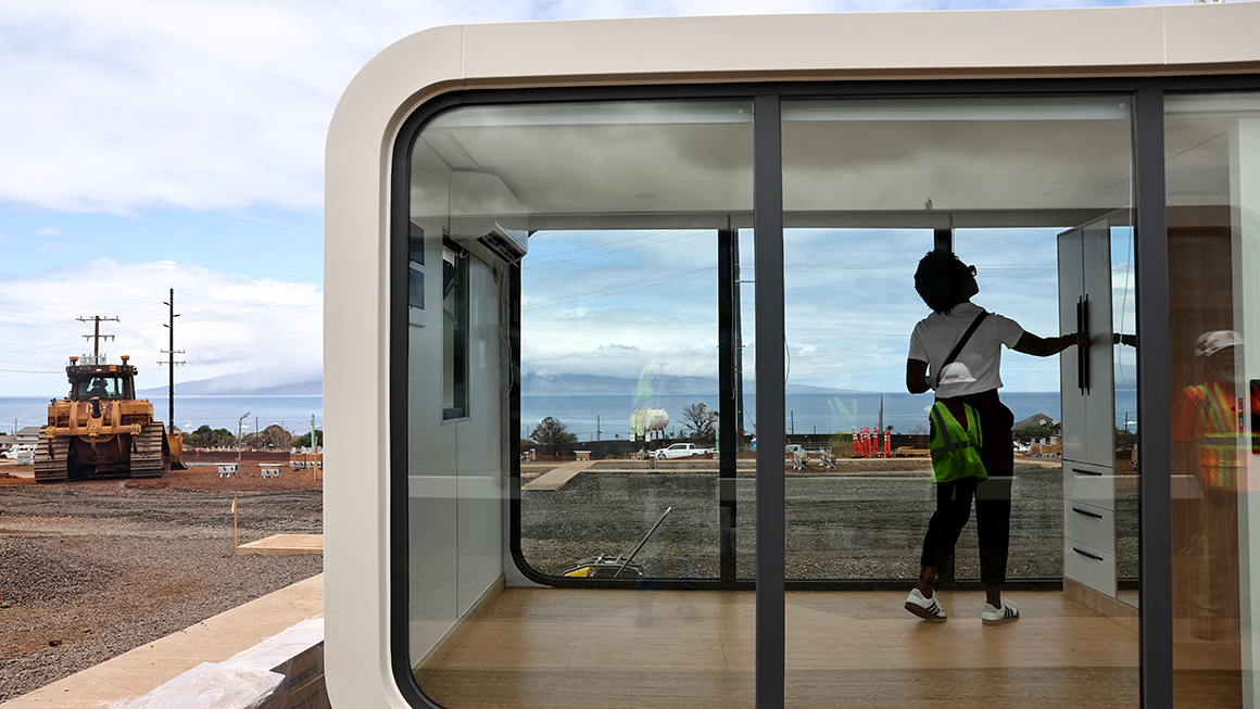 A FEMA official views a modular residential unit at the Ka Lai Ola temporary housing development in Lahaina, Hawaii