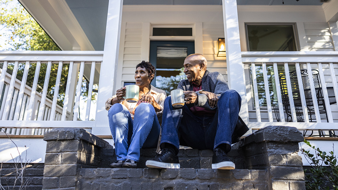 photo of couple sitting on front porch of house