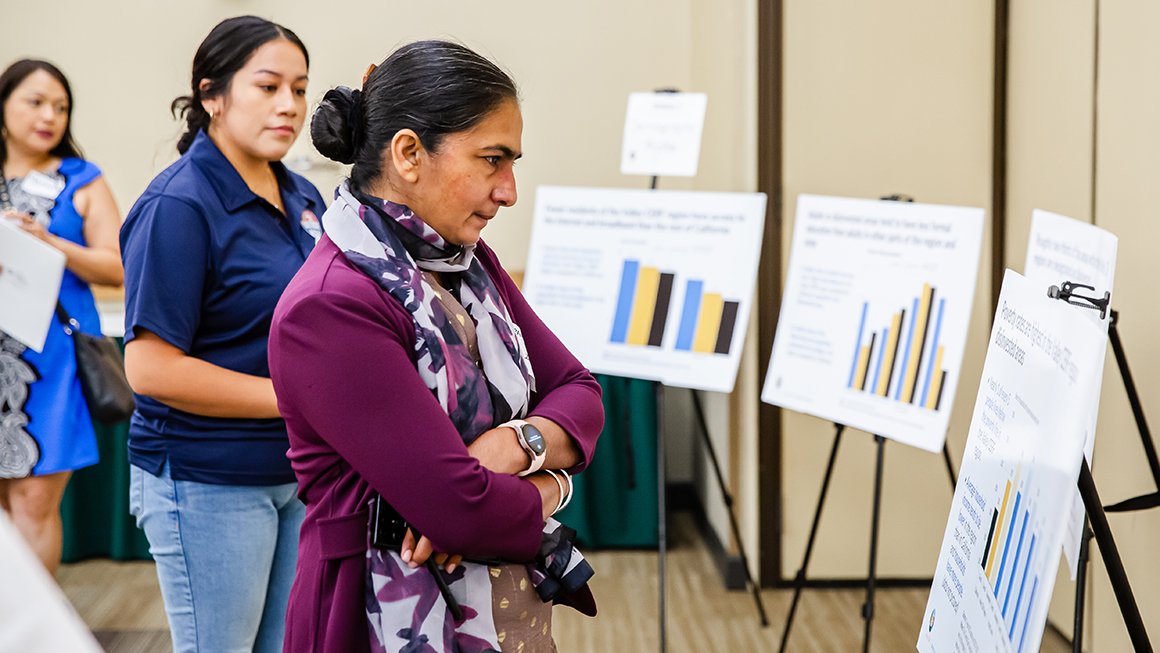 photo of woman looking at poster at meeting